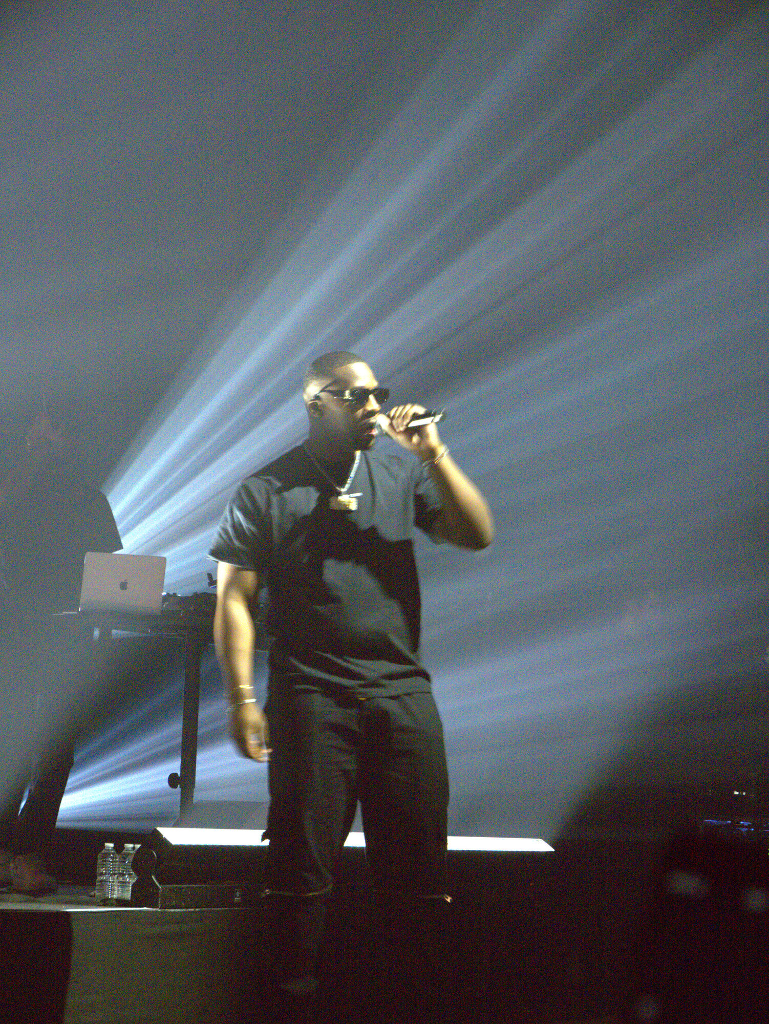 Rappeur SDM sur scène, faisceaux de lumière et fumée, photo 1