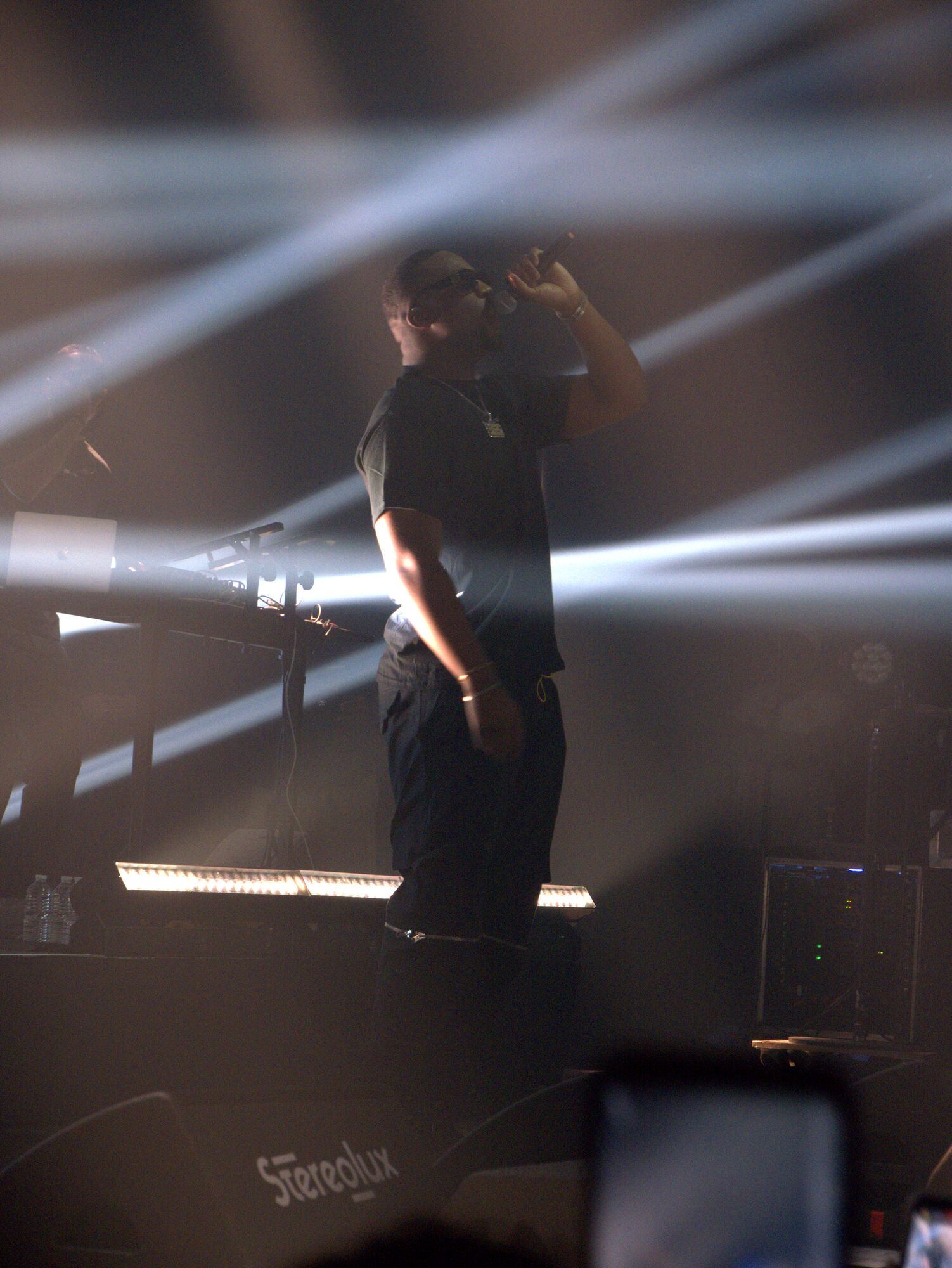 Rappeur SDM sur scène, faisceaux de lumière et fumée, photo 2