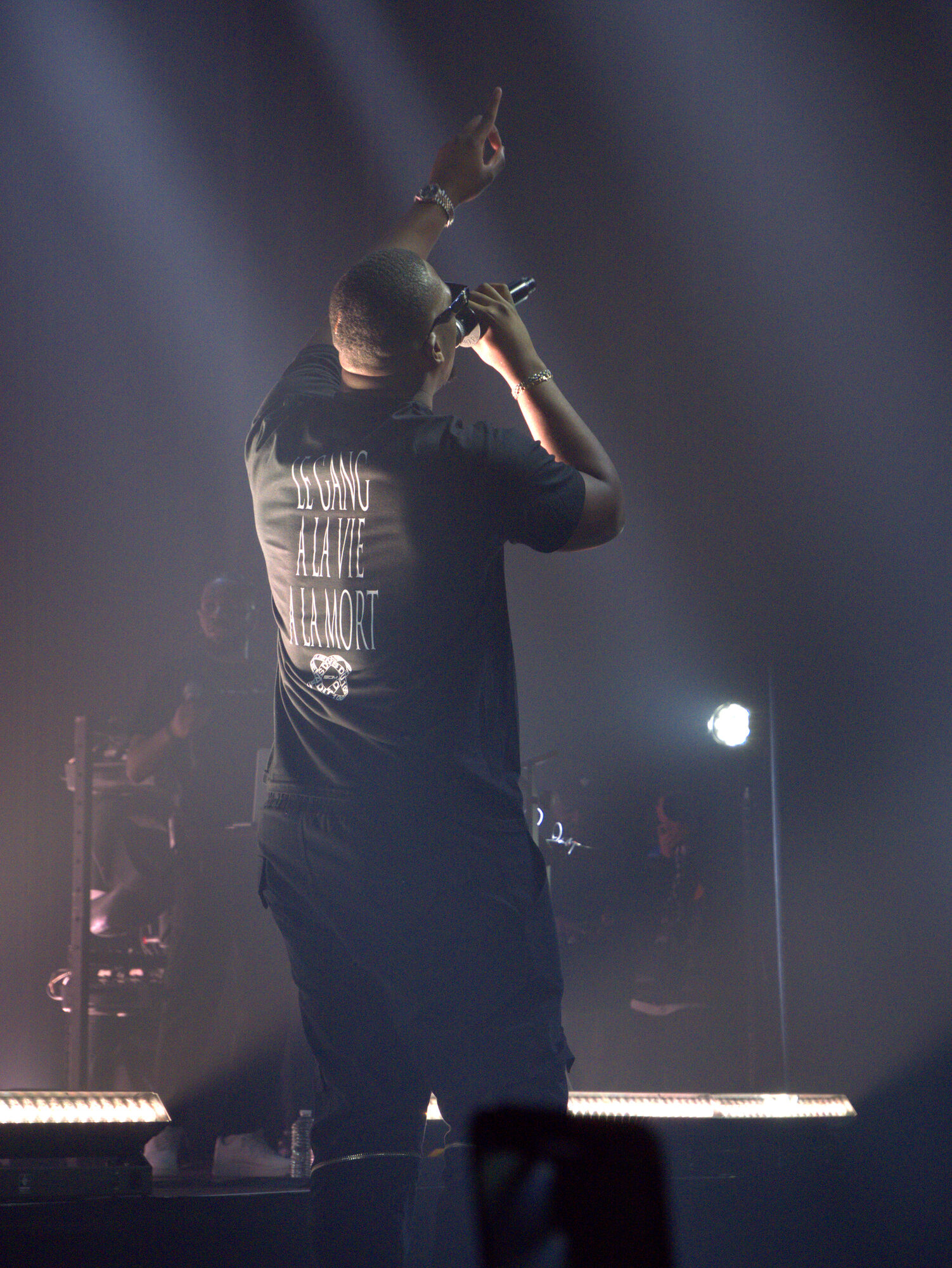 Rappeur SDM sur scène, faisceaux de lumière et fumée, photo 4