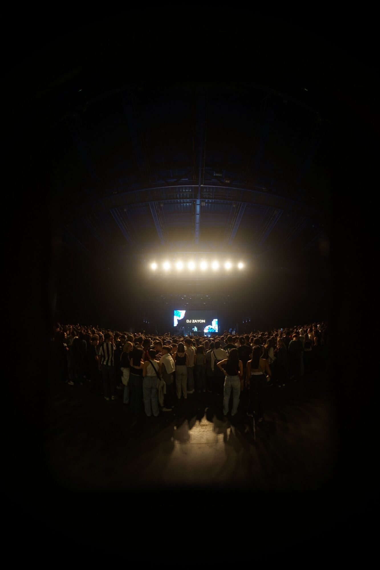 Public face à la scène, écran DJ Zayon au fond de la salle